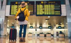 Young woman at the airport in Barcelona checking for the flight schedule