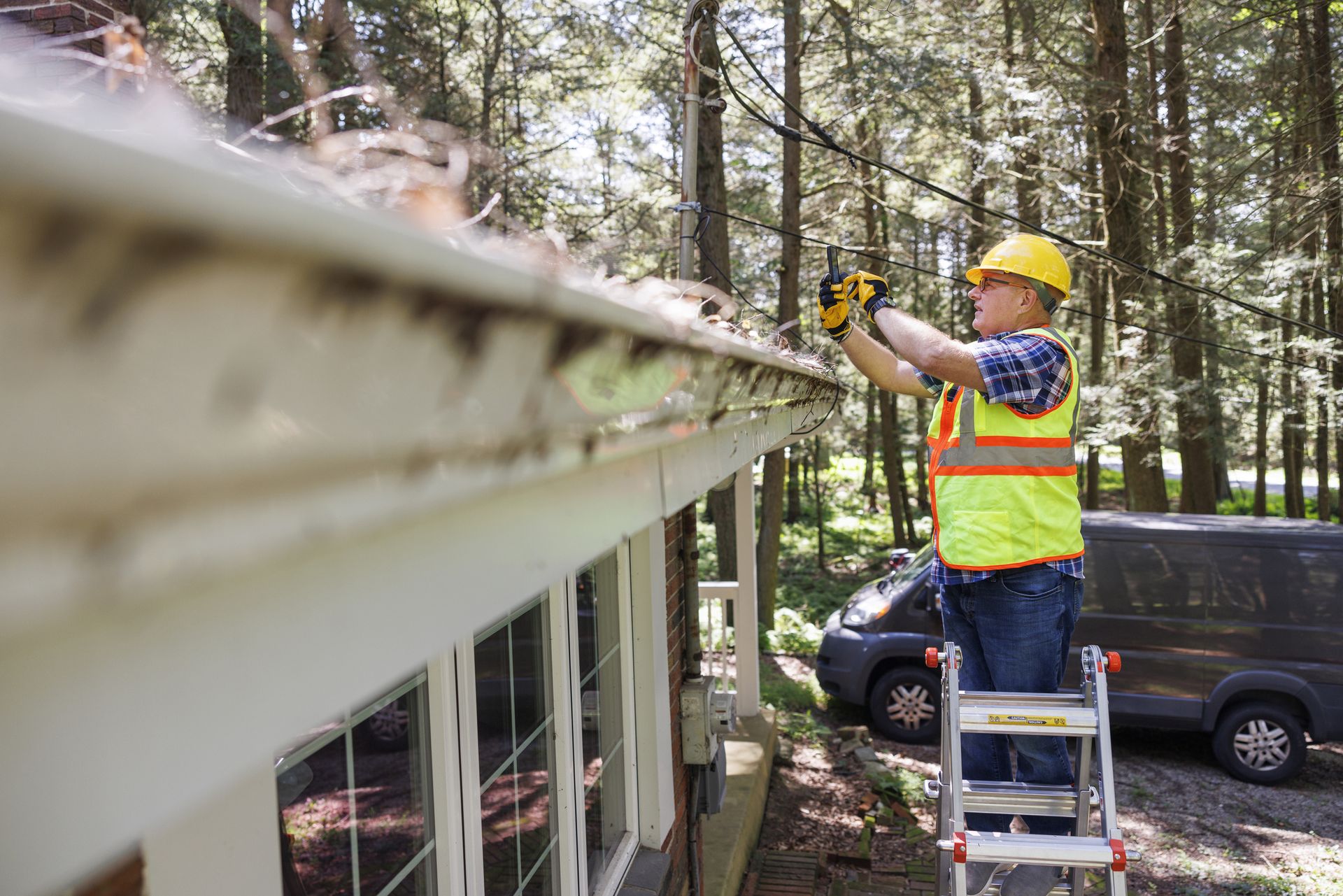 An insurance adjuster taking a photo of a roof damaged by a storm