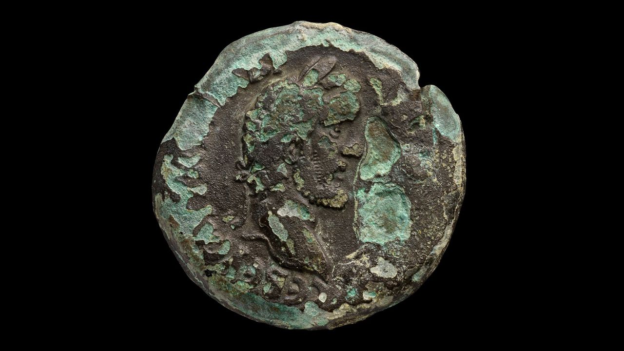 The profile of Roman Emperor Antoninus Pius on an ancient coin. It is very worn.