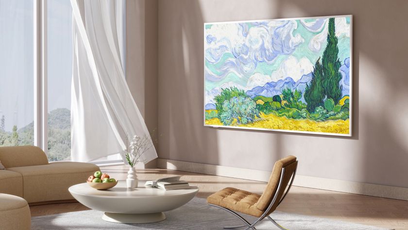 The picture frame-style TCL NXTVISION TV photographed mounted to a wall in a fancy living room. On the screen is an artwork.