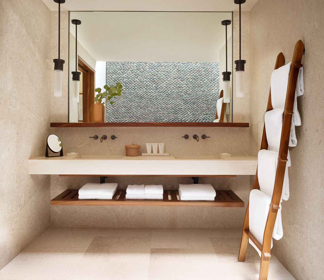 A bathroom floating shelf with neatly folded towels