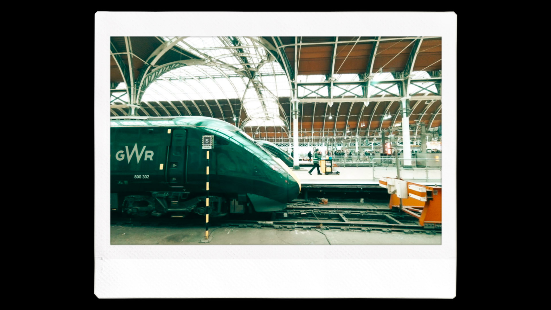 An Instax image printout of a train in a green hue filter