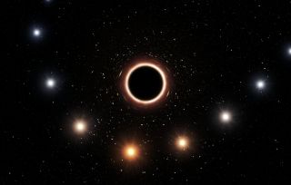 A star changes color as it circles around a black hole on a starry blackness.