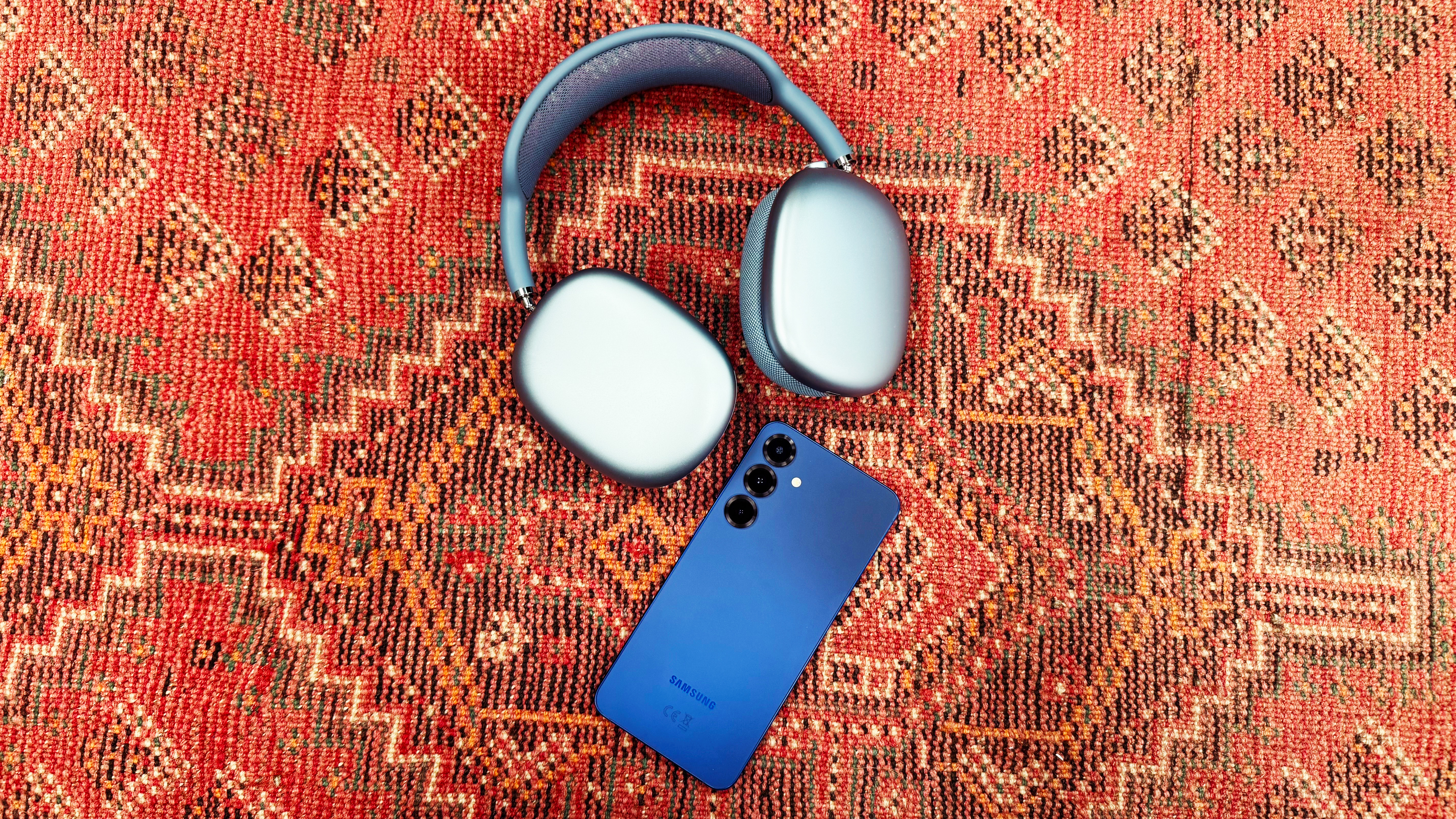 the airpods max 2 and samsung galaxy s25+ on a red rug 