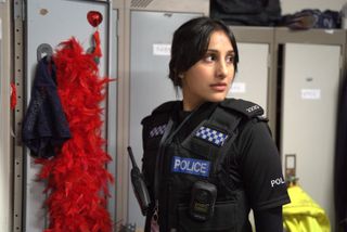 Rana at work by her locker stuffed with a feather boa.