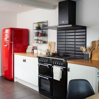 kitchen with white wall black chimney and red freeze