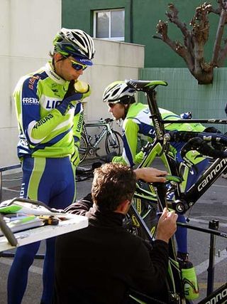 Aliaksandr Kuchynski aids the mechanic in bike setup.
