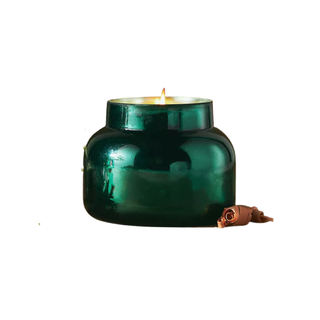 A candle in a green glass jar