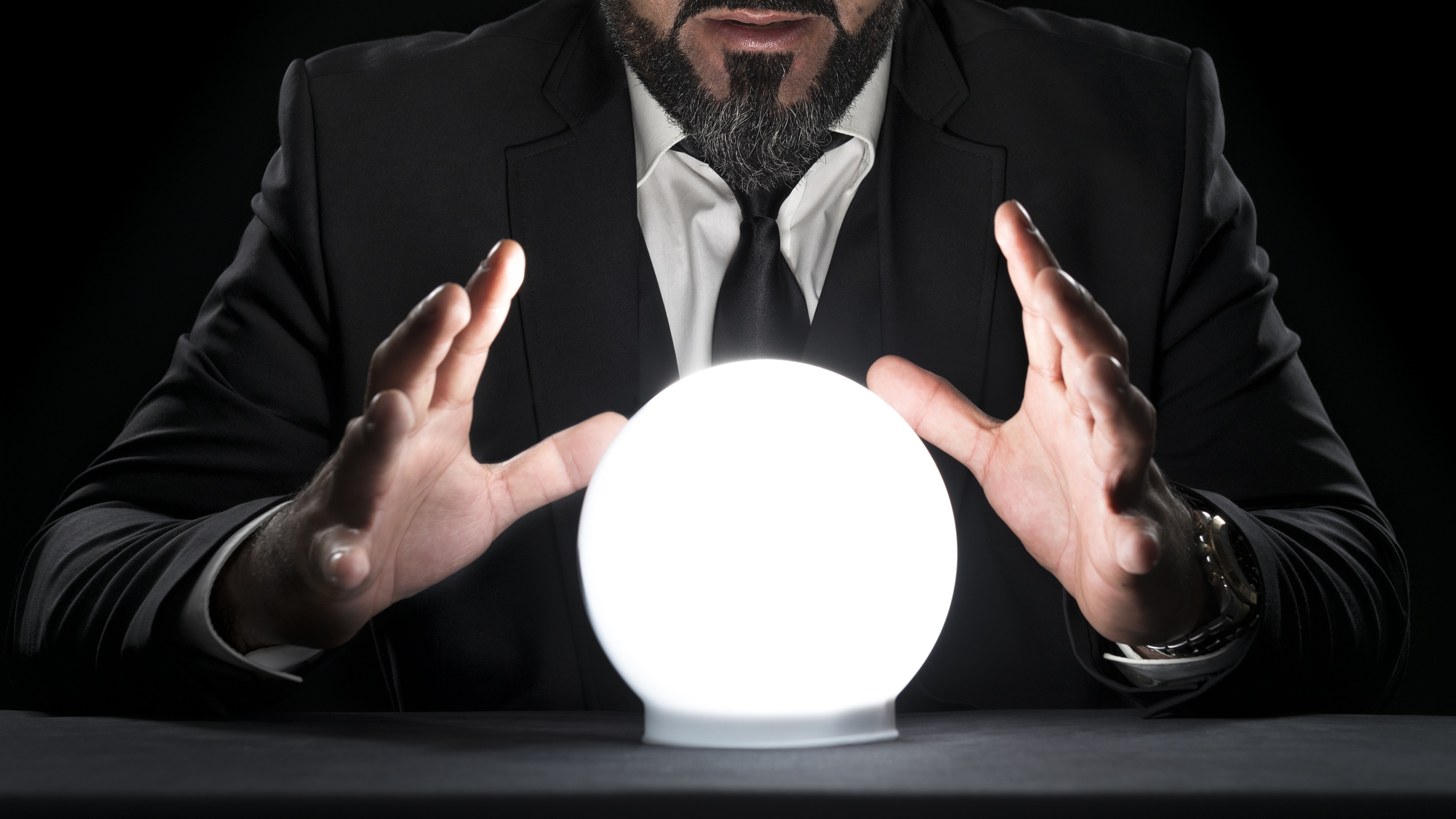 A man looks into a crystal ball.