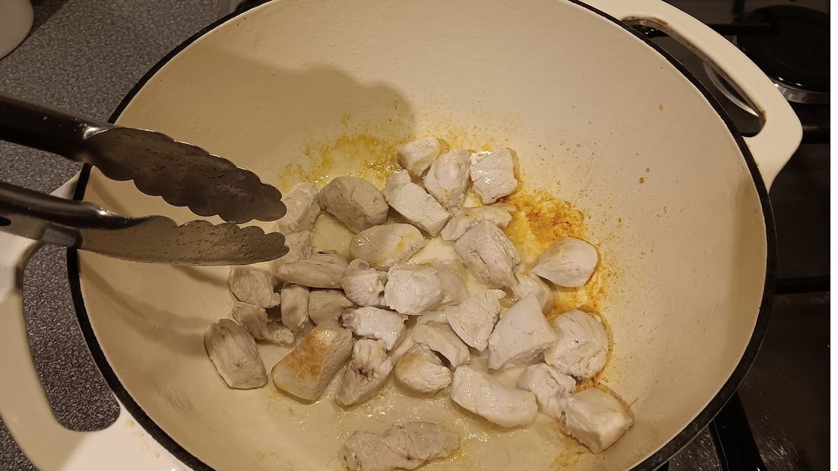 Chicken being seared in a Dutch oven