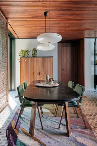 Dining room area at Il Sereno Hotel with an oval table and chairs upholstered in green velvet