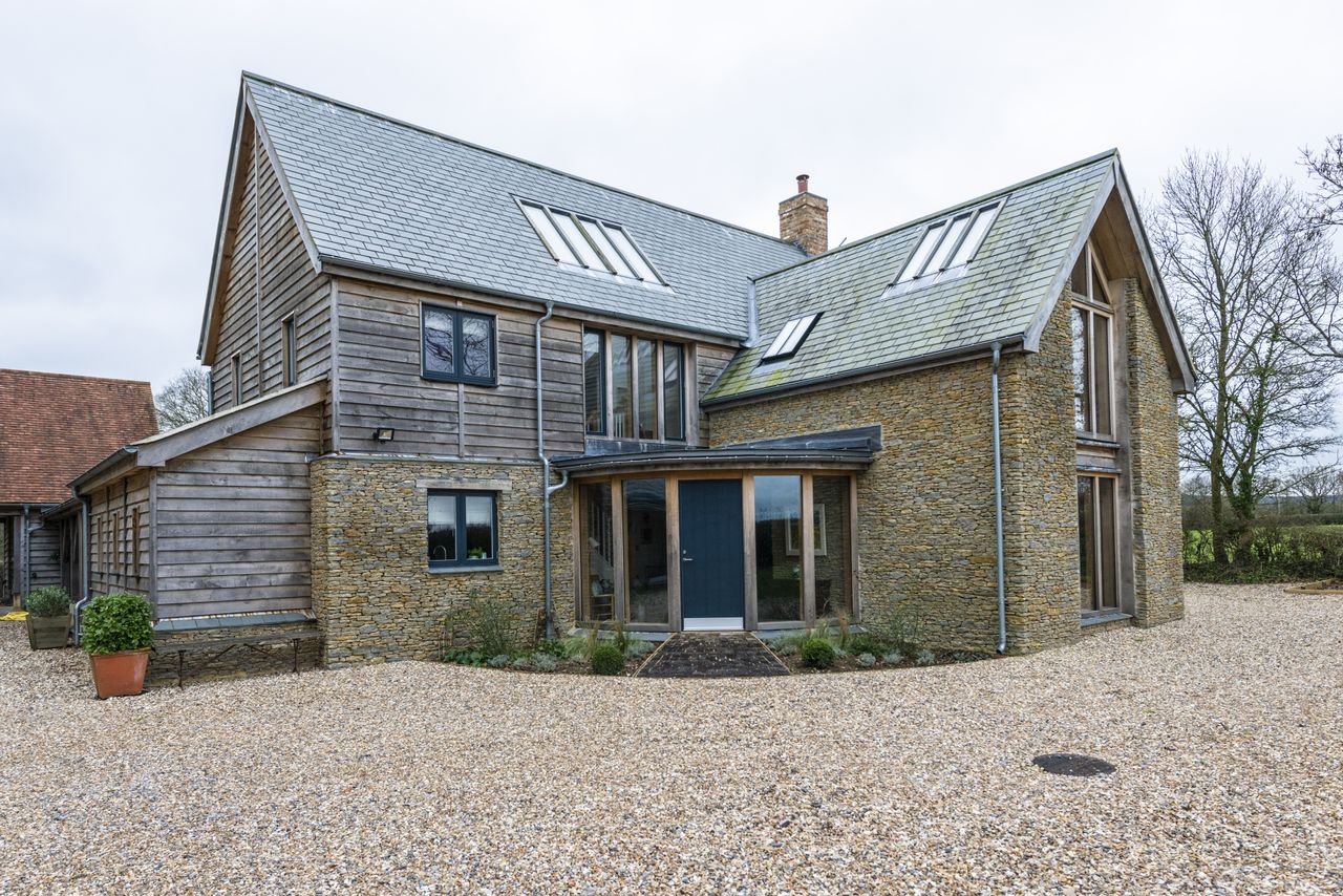 stone and timber clad self build with curved porch