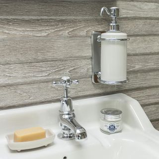wooden wall with white basin with soap and hand wash liquid