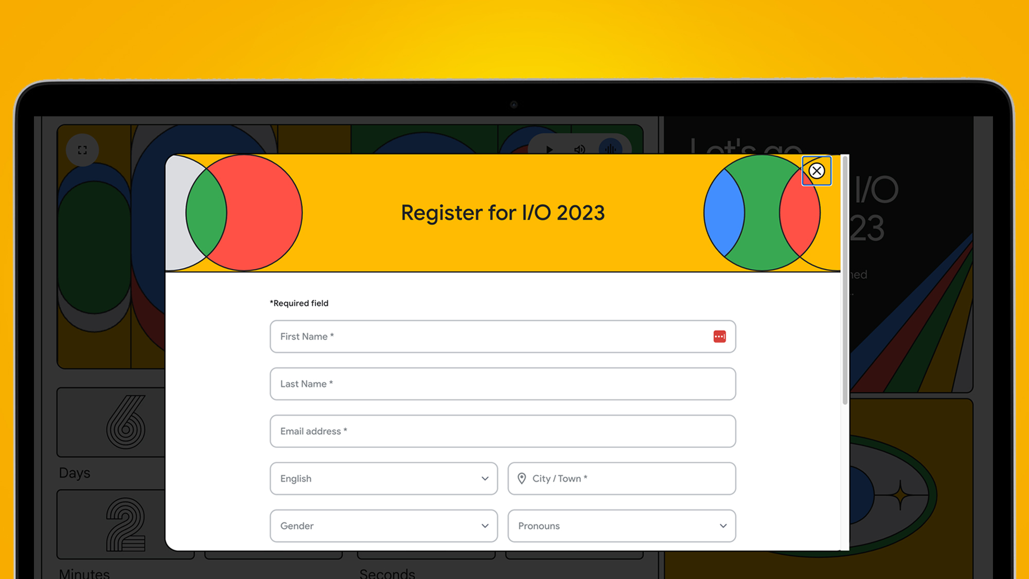 La pantalla de un portátil sobre fondo naranja muestra la página de inscripción para Google IO 2023