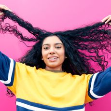a woman playing with her hair - affordable haircare