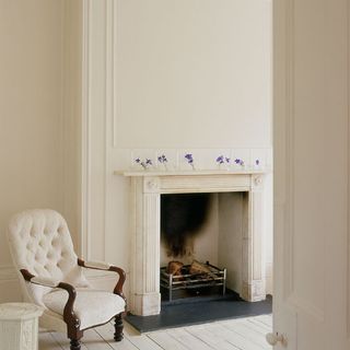white living room with white chair and fireplace