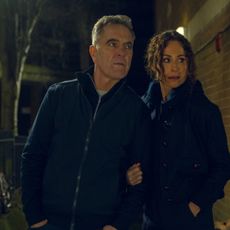 james nesbitt as simon and minnie driver as ingrid wearing all black sneaking around a building investigating in a scene from harlan coben's run away