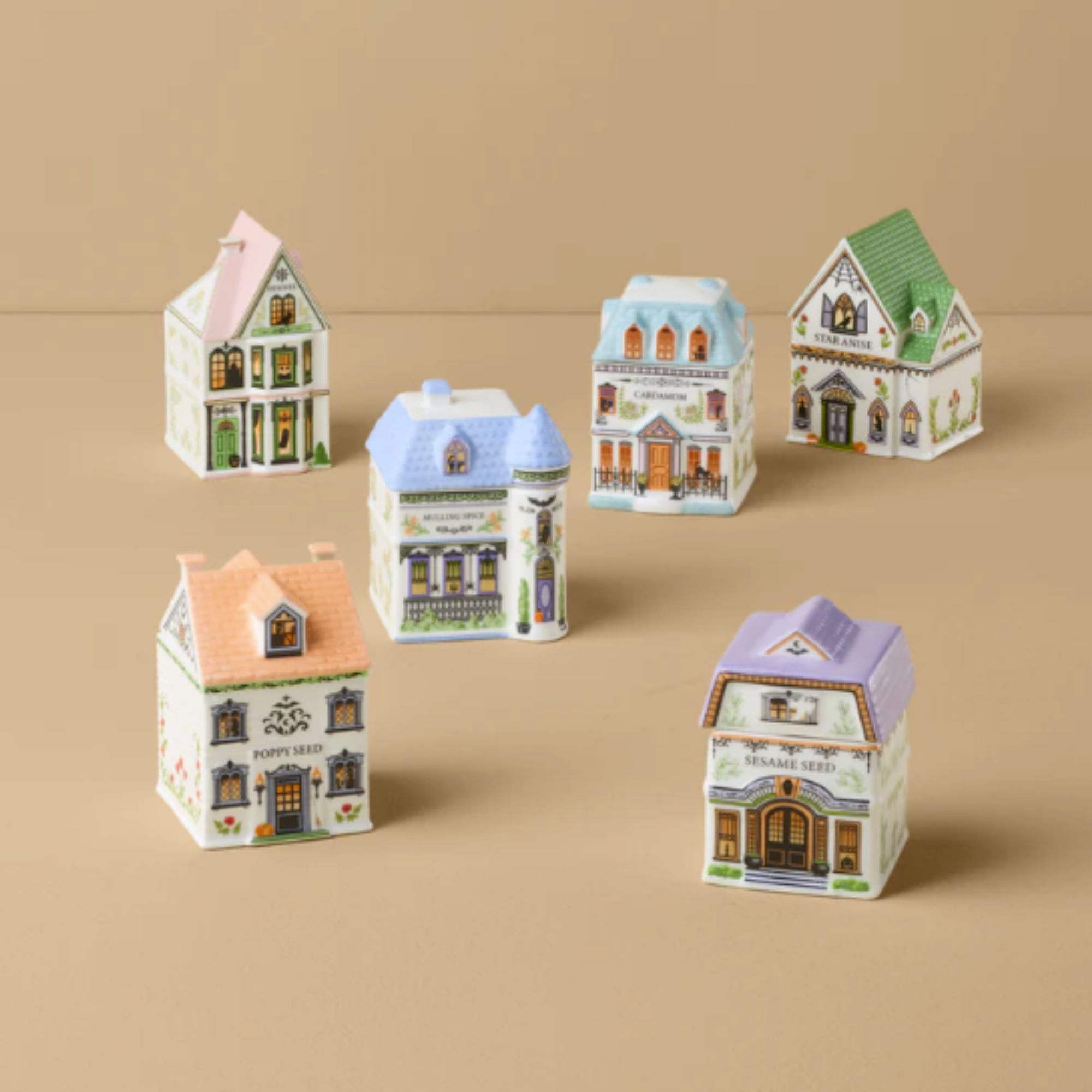 lenox Halloween spice village laid out on a light orange background.