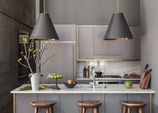 An industrial-style kitchen with oversized pendants above the island