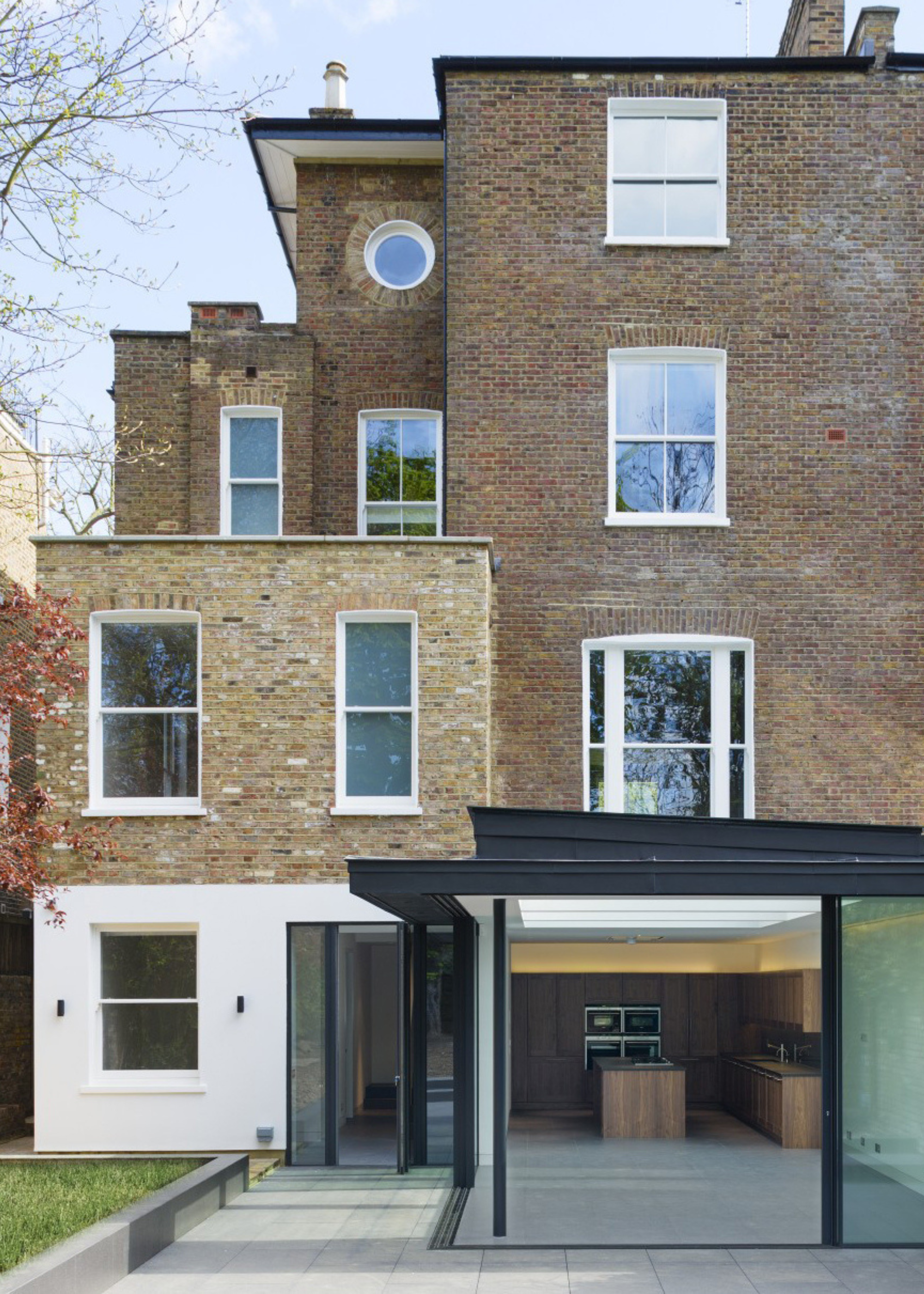 brick extension on victorian home with picture window with benchseat, brick flower beds, and decking