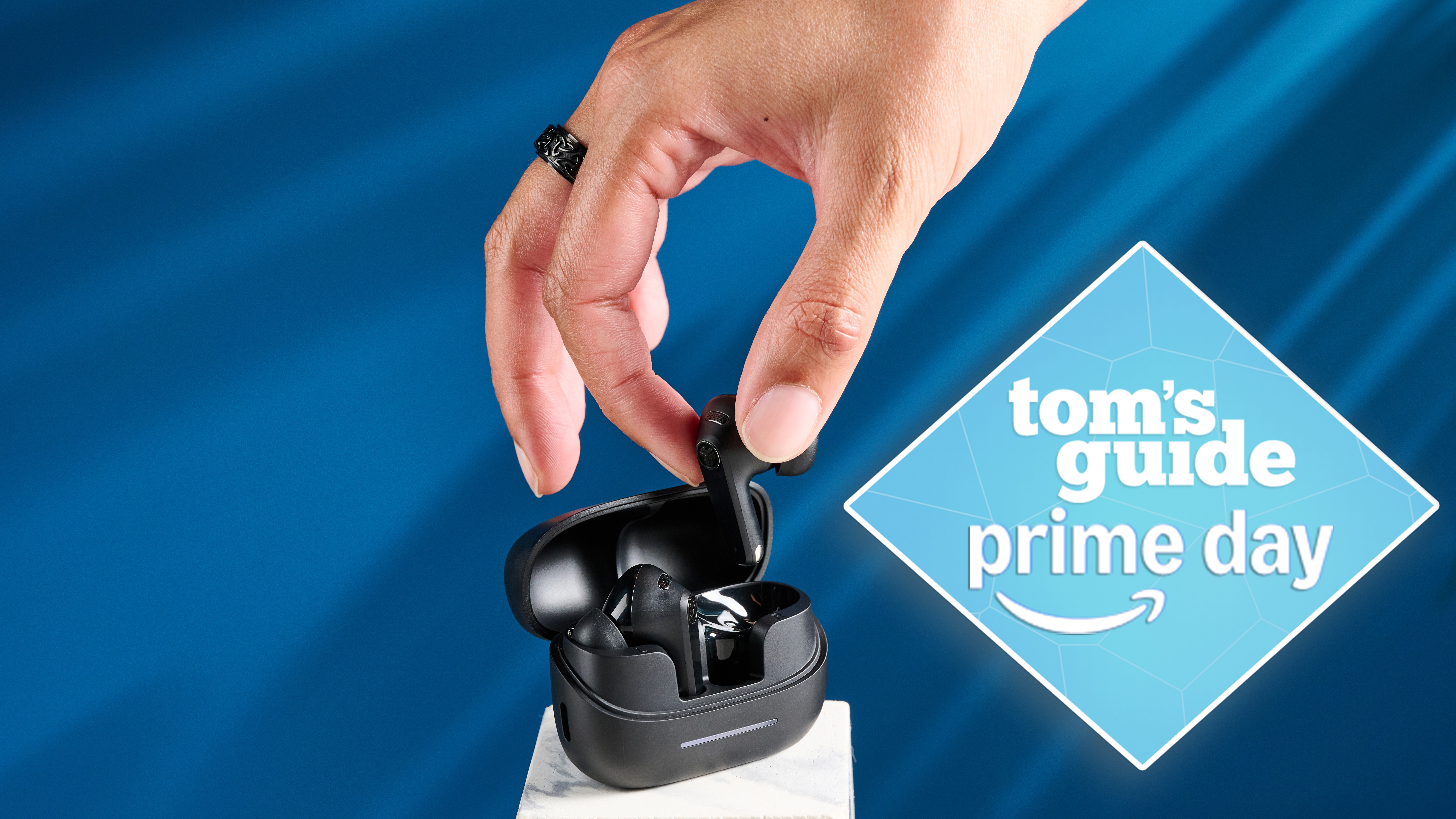 a photograph of the jlab go pods anc earbuds against a blue background with a light blue tom's guide prime day badge