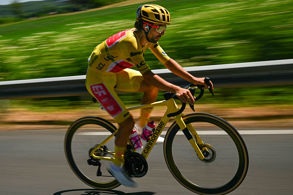 EF Education - EasyPost team's Irish rider Ben Healy wearing the overall leader's yellow jersey cycles with the pack of riders (peloton) during the 12th stage of the 112th edition of the Tour de France cycling race, 180.6 km between Auch and Hautacam, in the Pyrenees mountains of southwestern France, on July 17, 2025. (Photo by Loic VENANCE / AFP)