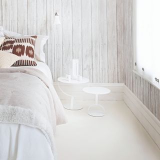 A white tonal bedroom with patterned cushions
