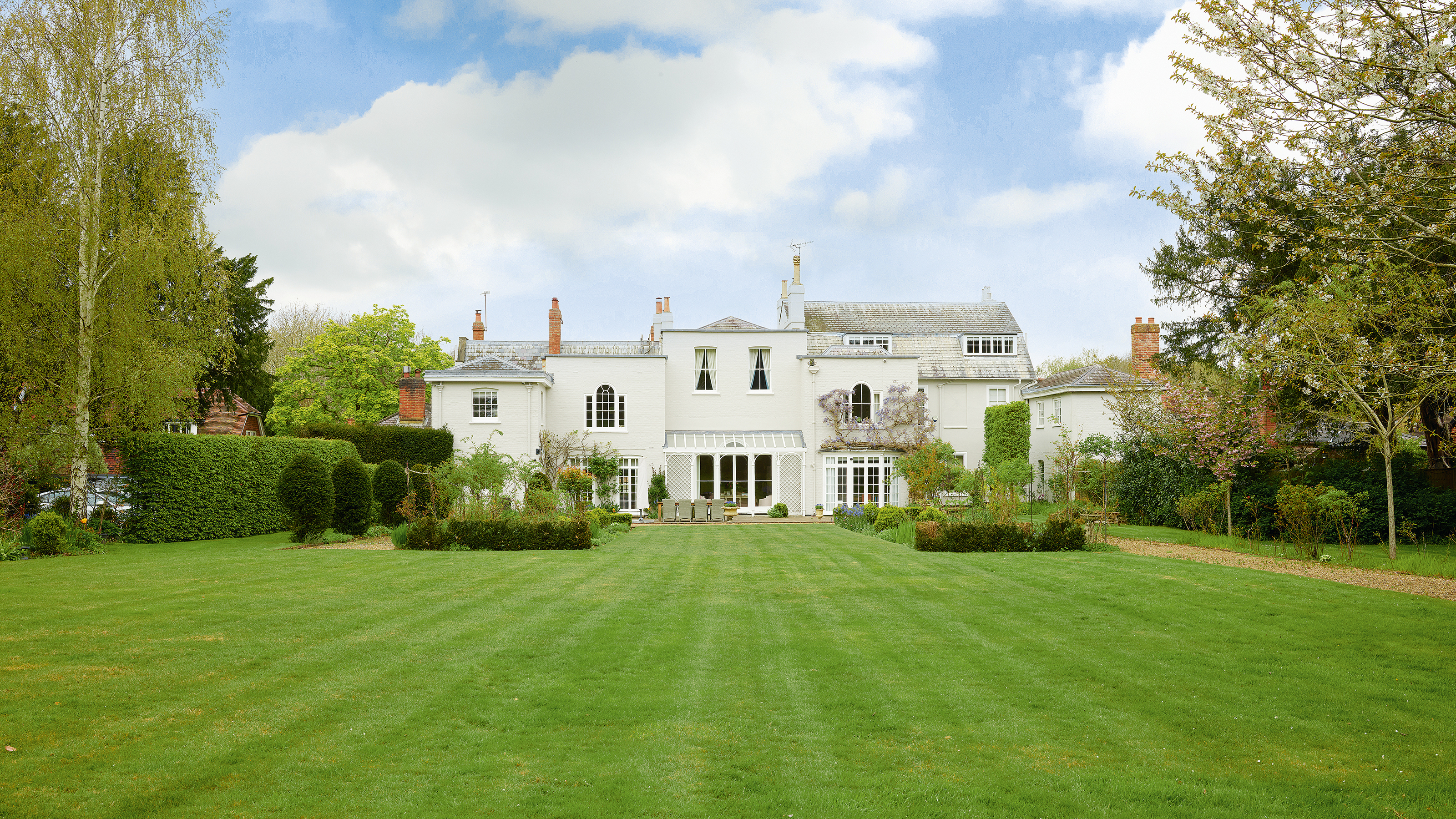 rear exterior of a white painted georgian property with large lawn area