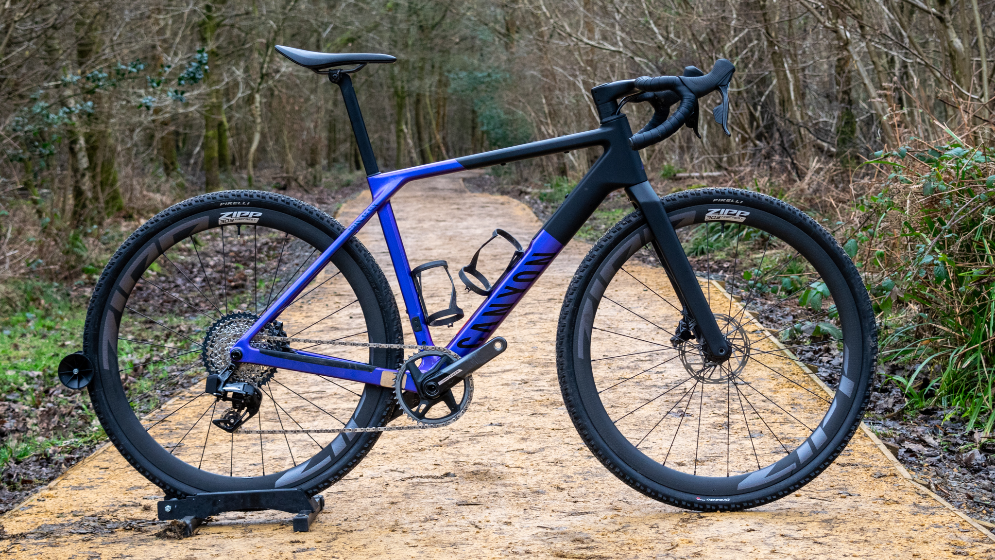 A purple and black Canyon Grail CF SLX in woodland