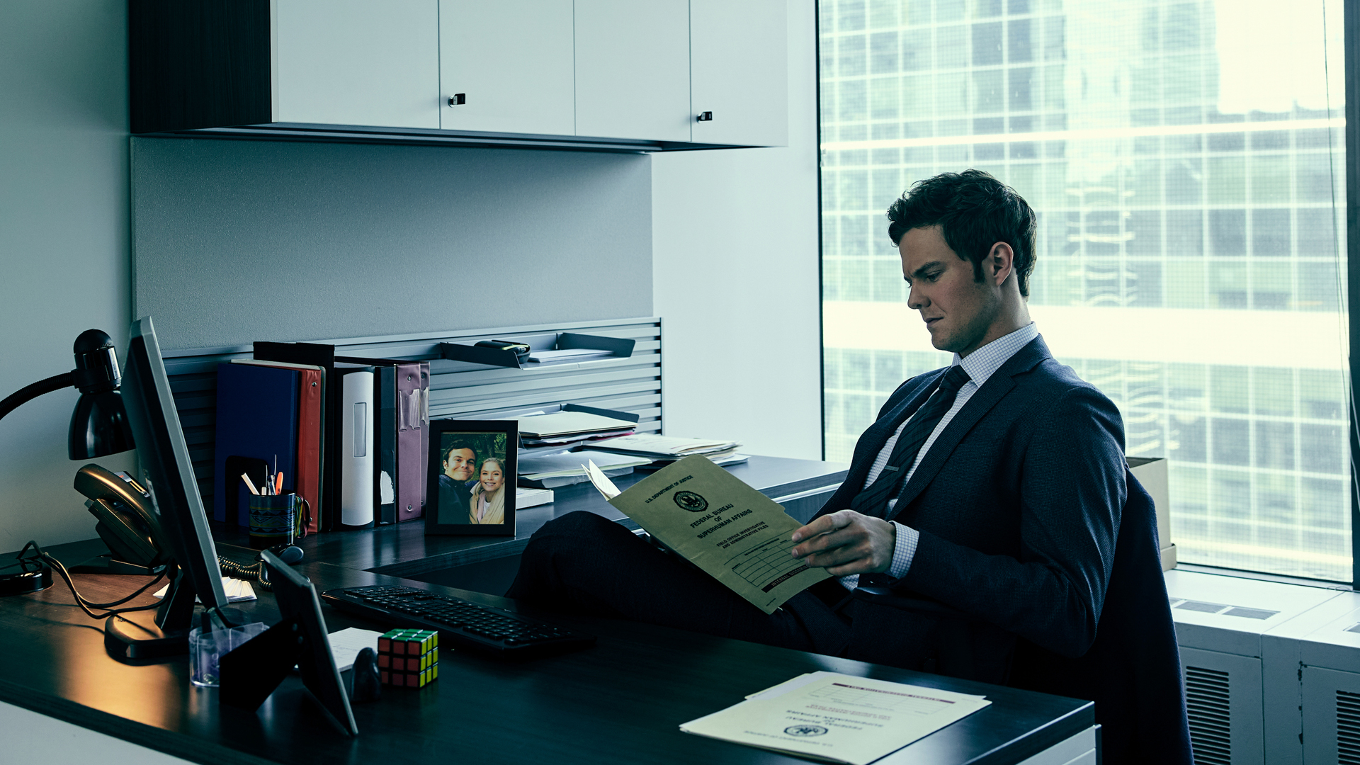 Hughie Campbell sits at a desk reading some files in The Boys season 3