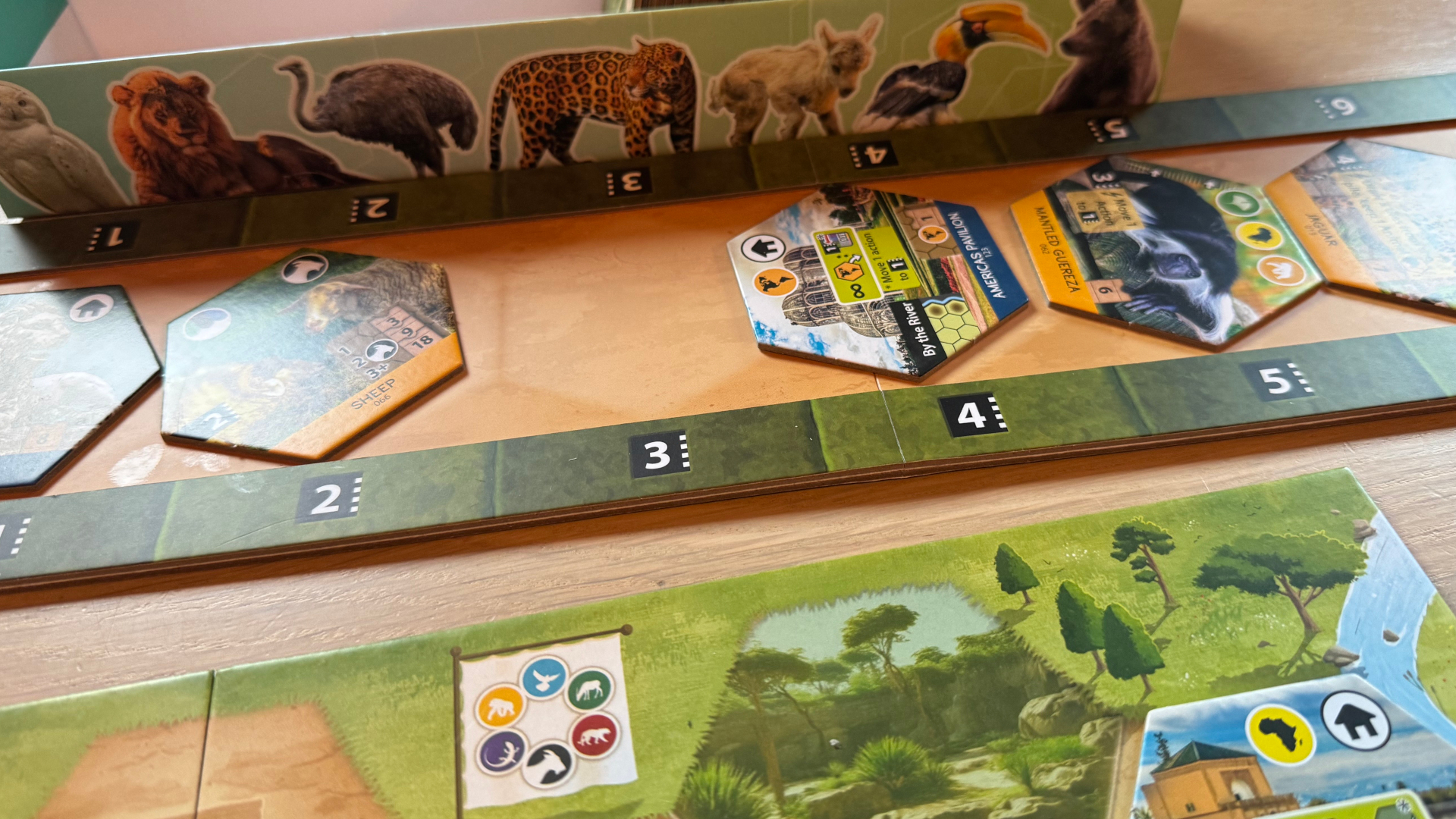 A series of Sanctuary tiles and boards laid out beside the box