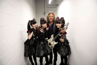 Kirk gives the girls a quick guitar lesson backstage