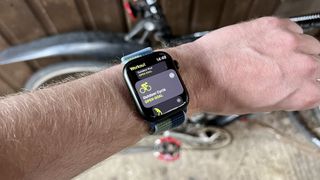 Apple Watch Series 7 in front of a bike, ready to workout.