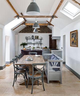 Kitchen with bench seating, dining table and wooden beams