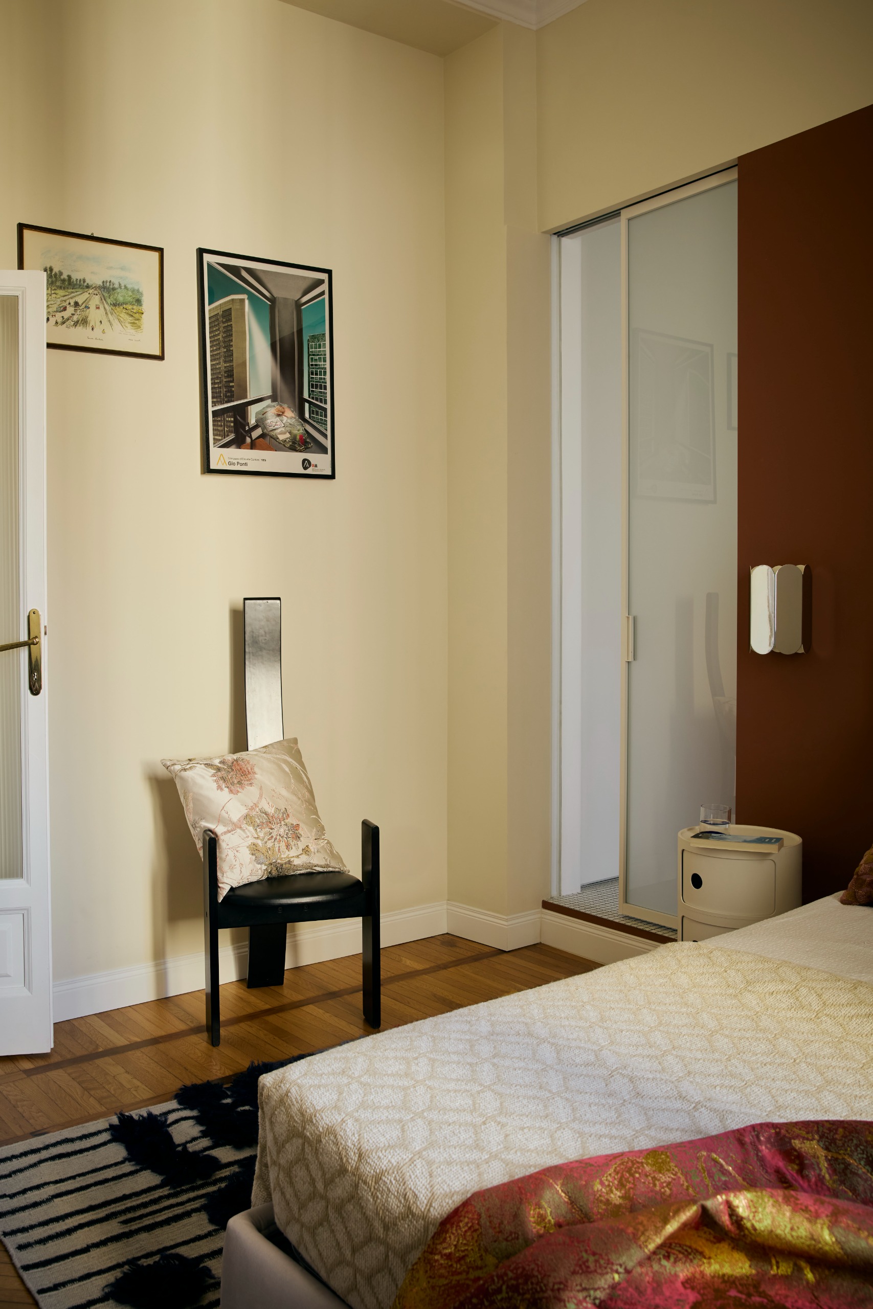 modern eclectic bedroom with an ensuite behind a sliding door and modernist furniture throughout