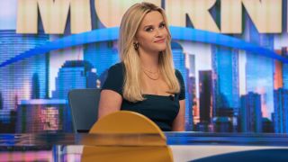 Reese Witherspoon sitting at the desk of The Morning Show.