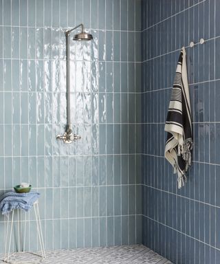 Light blue and dark blue shower tiles with white mosaic floor tiles by Mandarin Stone