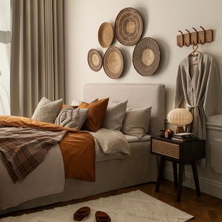 Bedroom with cream walls and beige and rust bedding