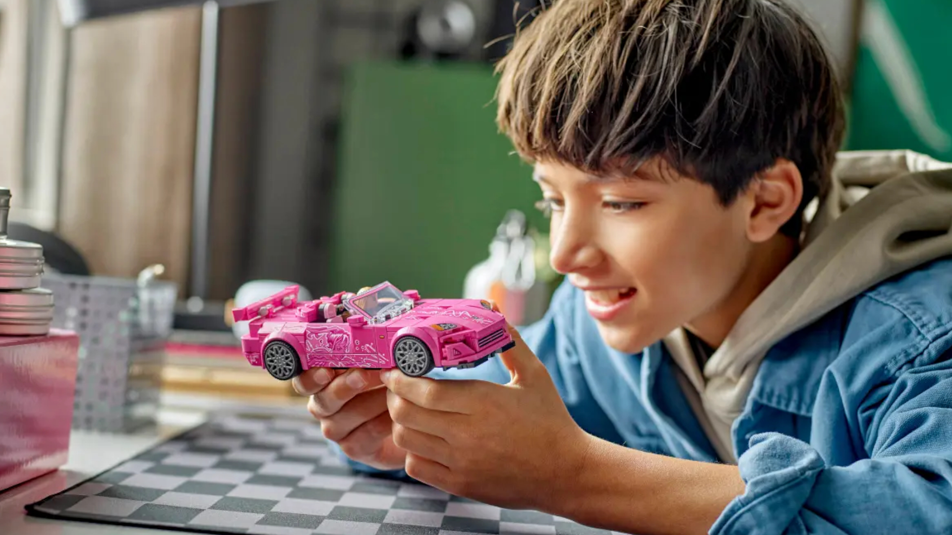 A child smiles while holding the Lego 2 Fast 2 Furious Honda H2000 kit