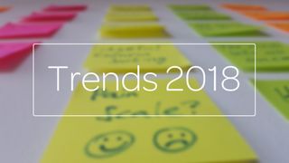 Trends 2018 title typed over a photo of a table full of post-it notes