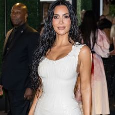 Kim Kardashian wearing a white dress and long wet-looking hair. 