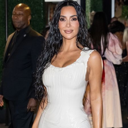 Kim Kardashian wearing a white dress and long wet-looking hair. 