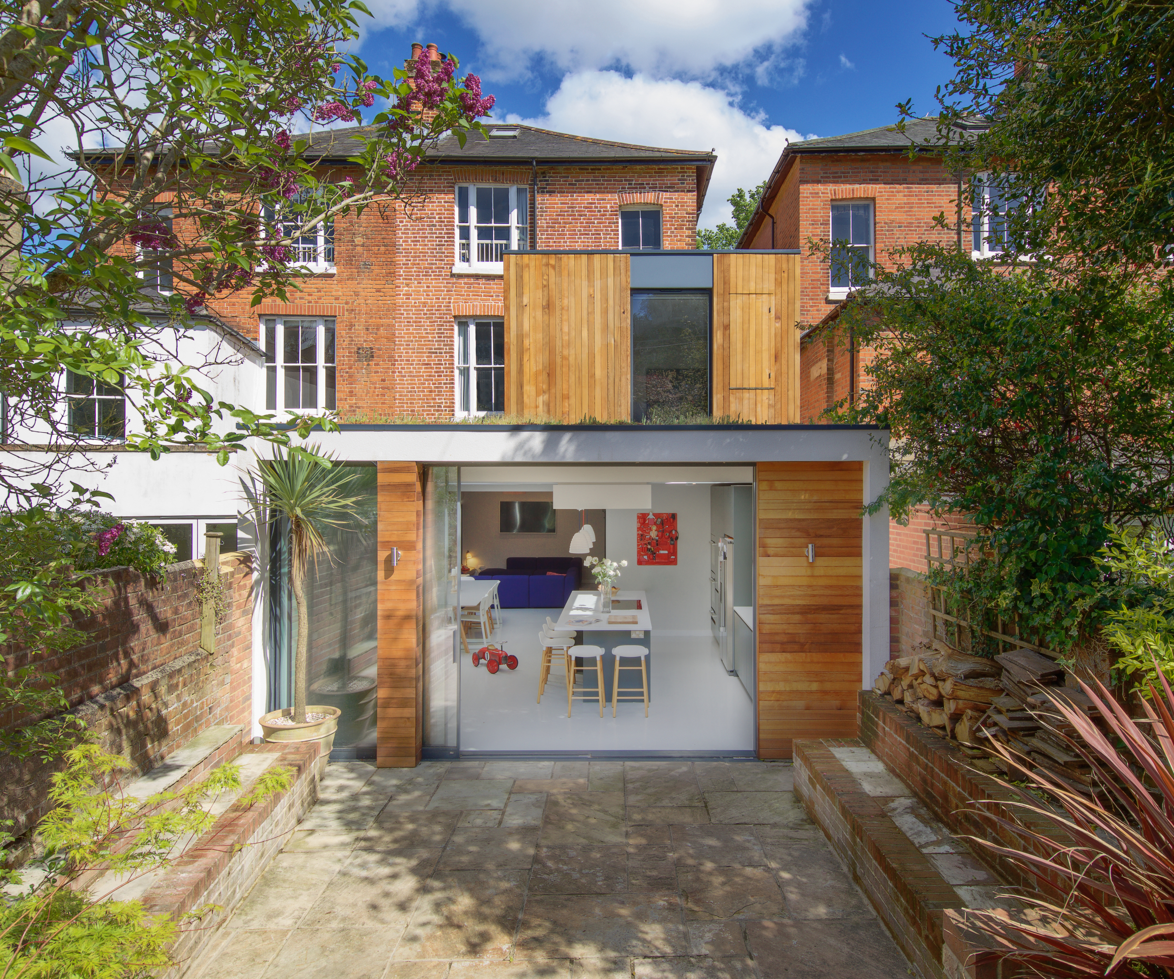 double storey extension added to rear of brick semi-detached house with timber cladding on both sections but laid horizontally on lower level and vertically on top