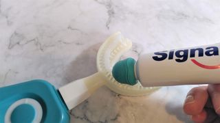 Applying toothpaste to the Y-Brush