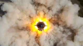 overhead view of starship surrounded by flame and smoke