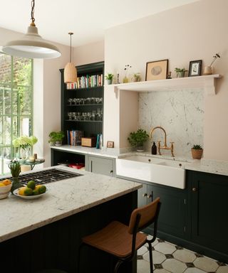 A green and pink kitchen with the sink installed in a chimney breast