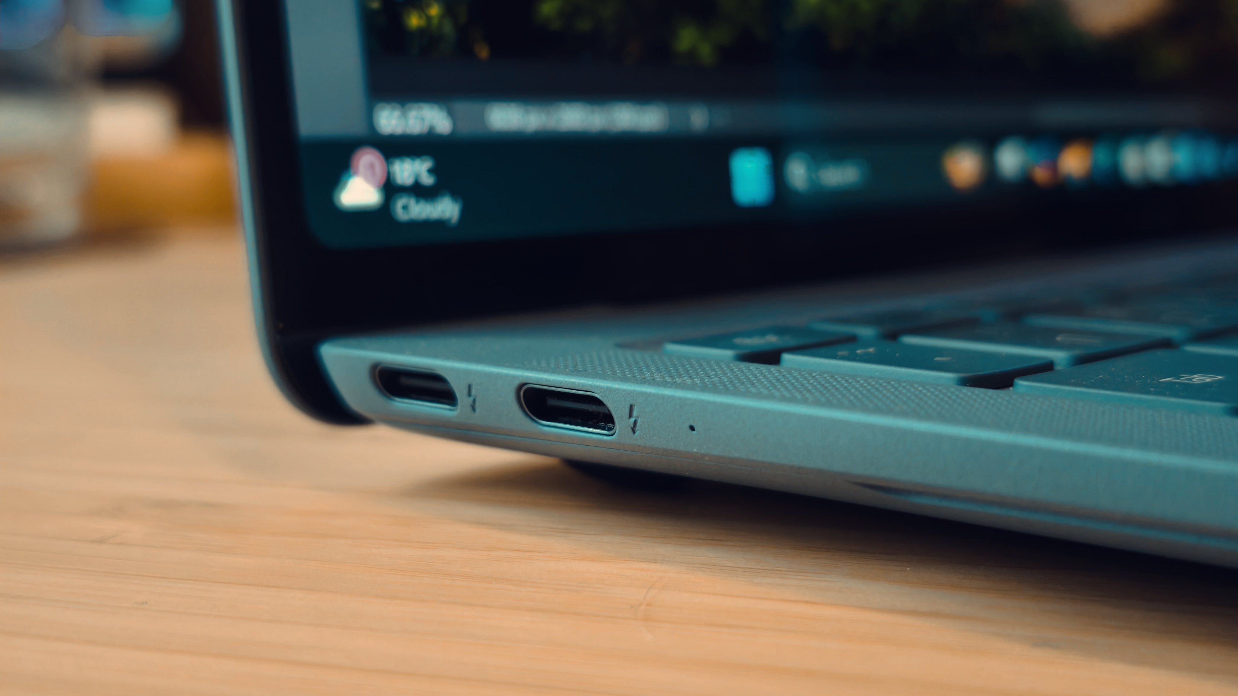 A blue Huawei Matebook X Pro laptop on a wooden desk, in front of blue and orange LED lights.