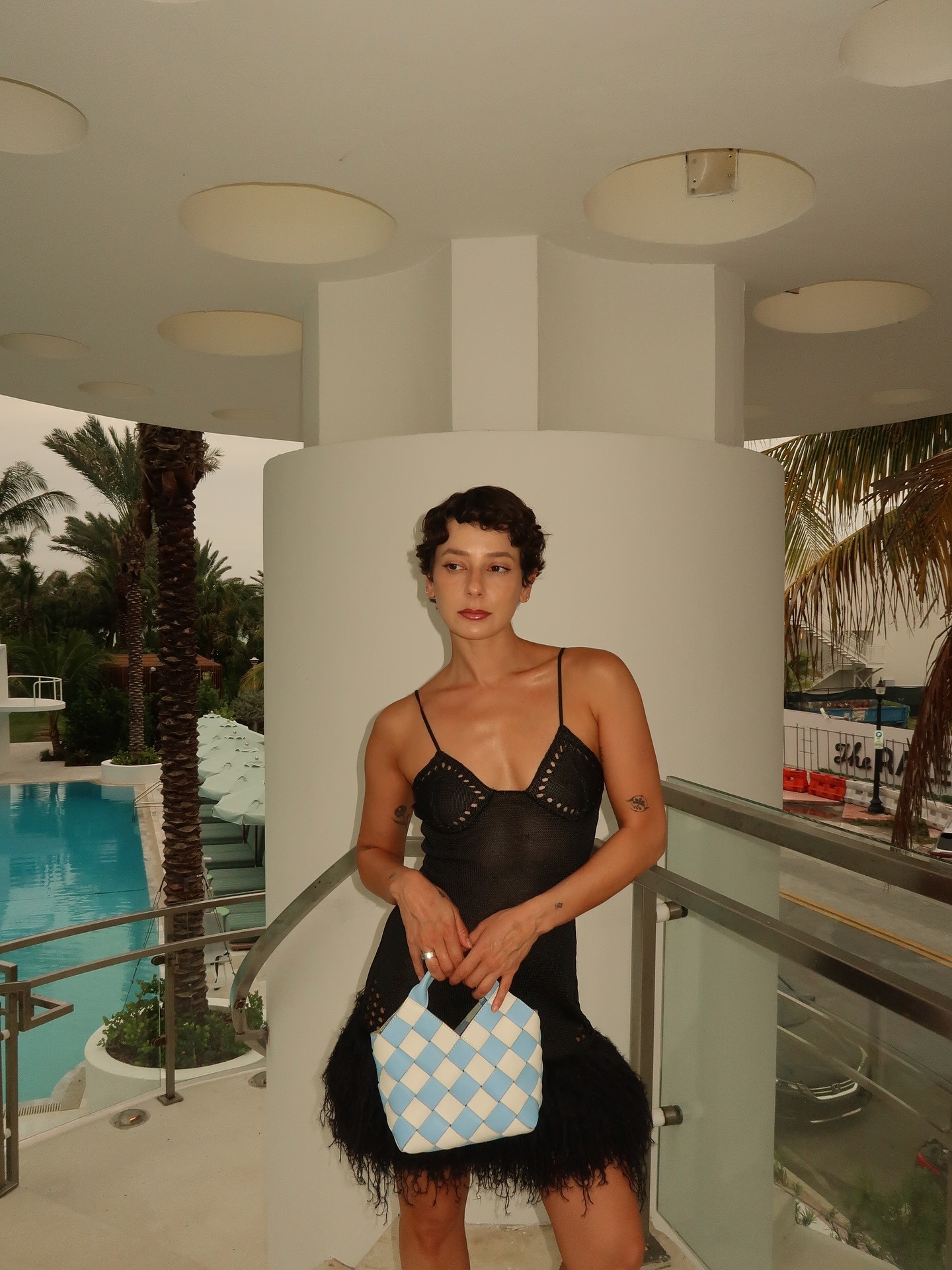A woman in Miami wearing a mini dress with a glamorous pixie haircut