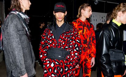 Group of models, 3 looking away and one looking directly at the camera with a cap on.