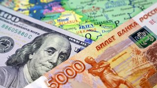 100 dollar bill and 5,000 ruble bill on a map